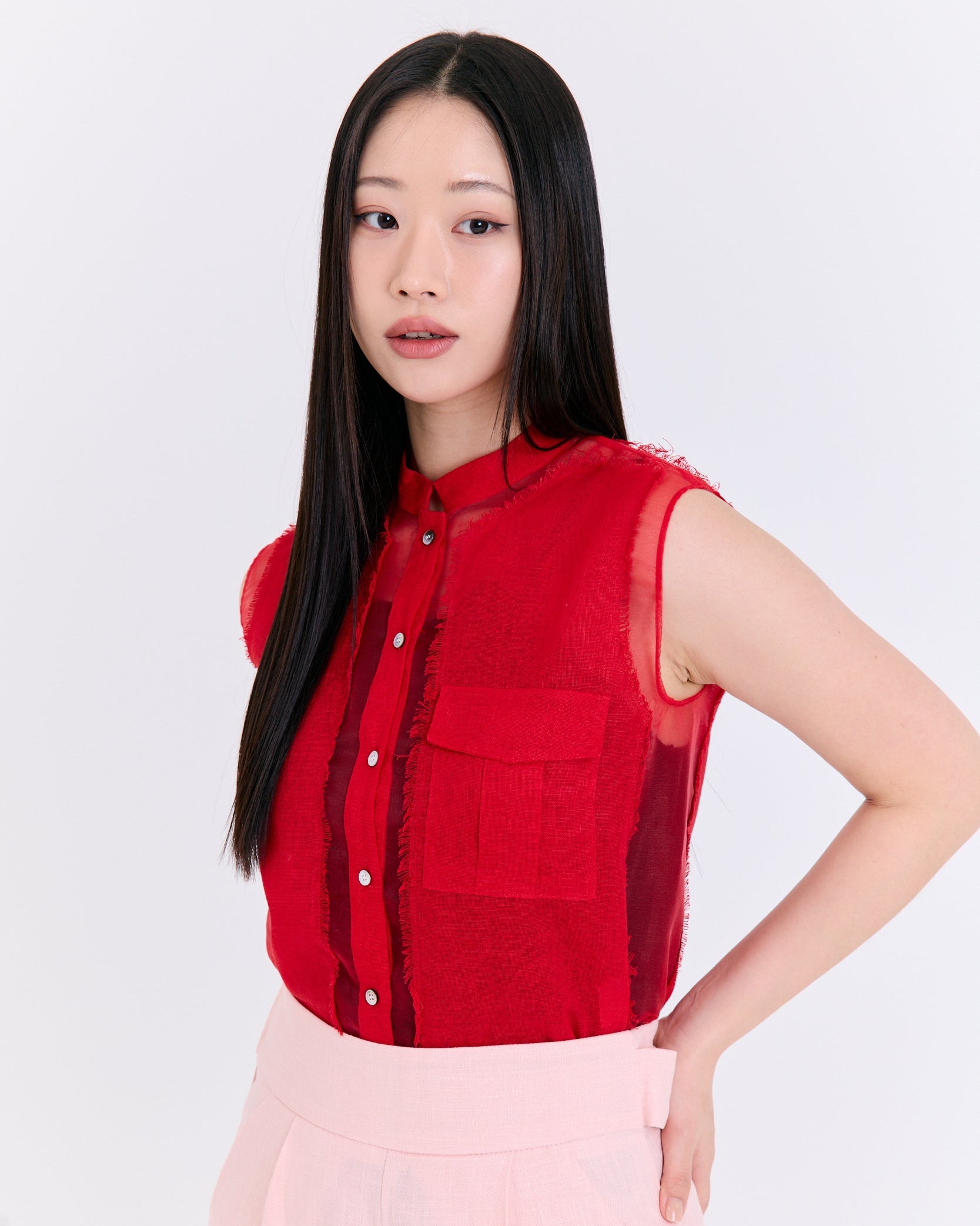 Woman wearing a red sleeveless top with a white background