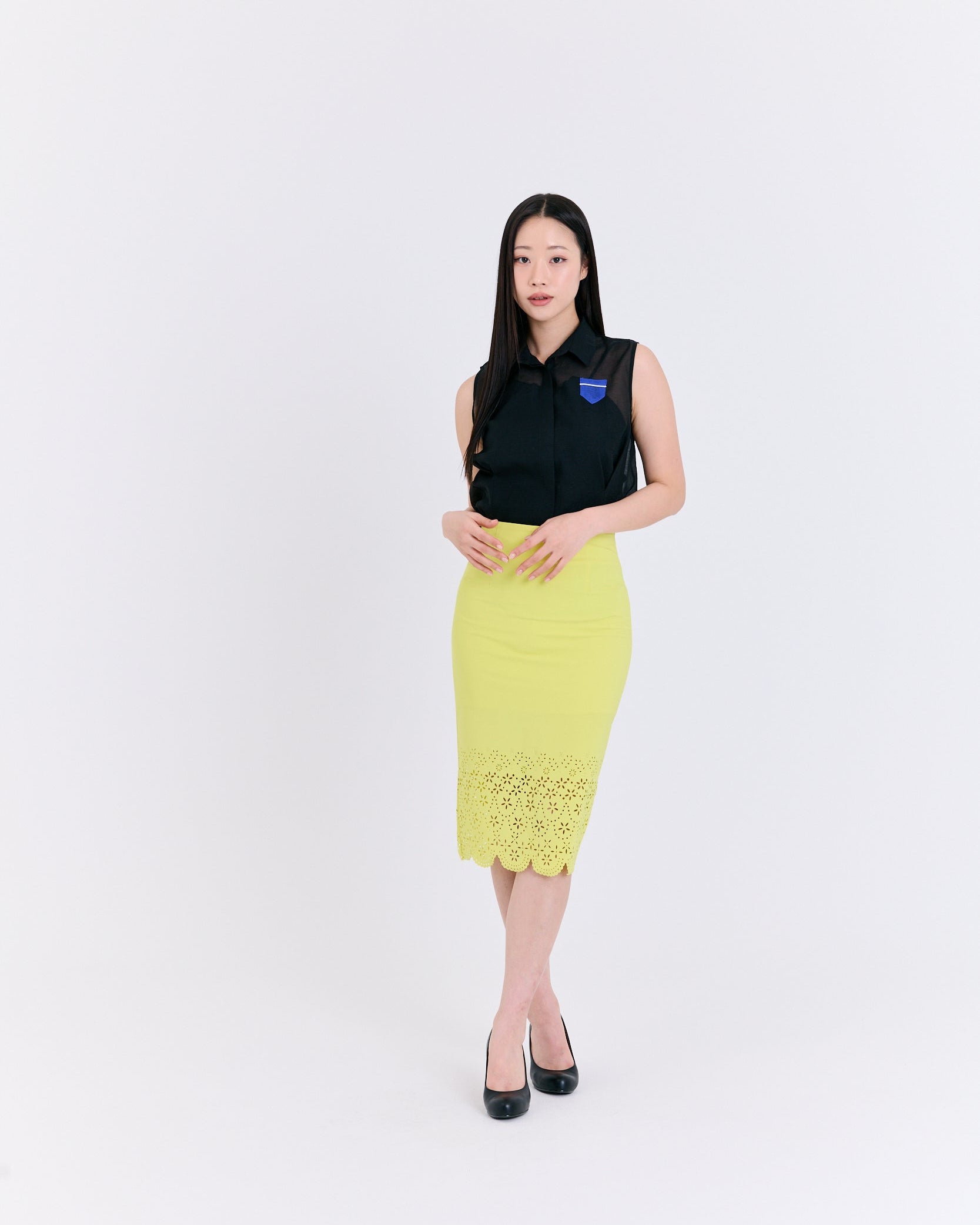 Woman wearing a black top and yellow skirt on a white background