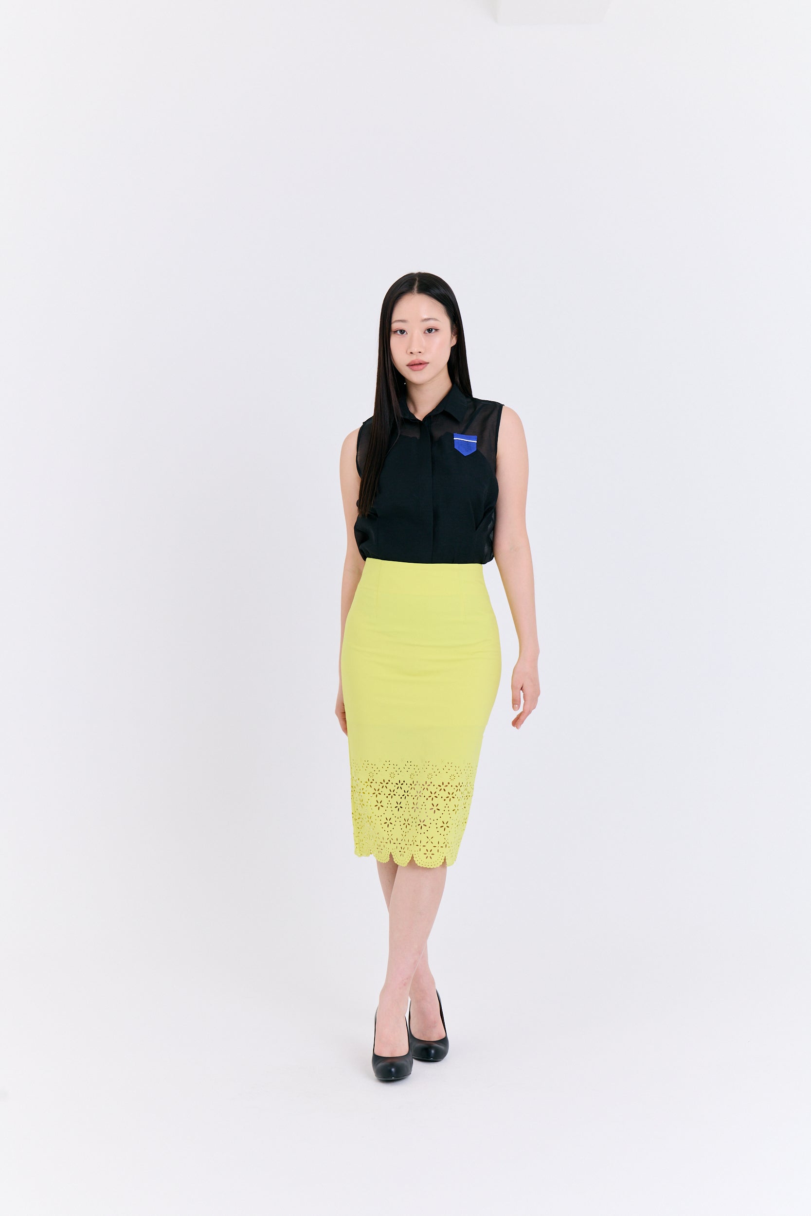 Woman wearing a black top and yellow skirt on a white background