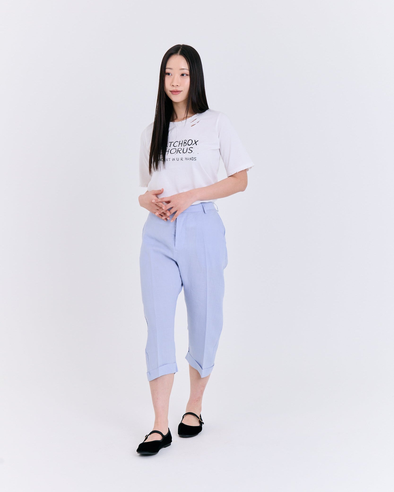 Person wearing a white t-shirt and light blue pants on a white background