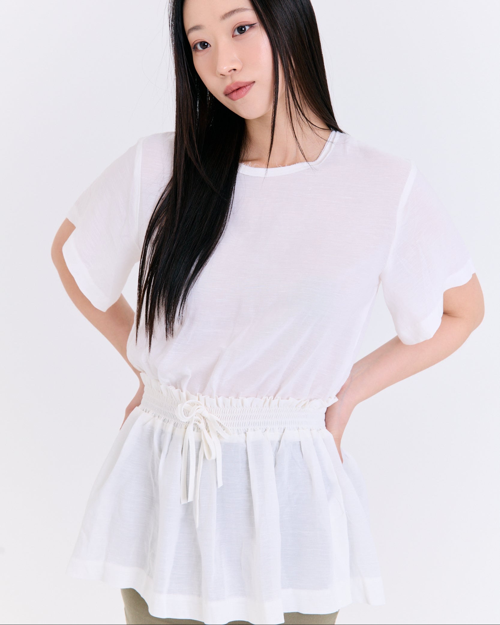 Woman wearing a white dress with a plain background