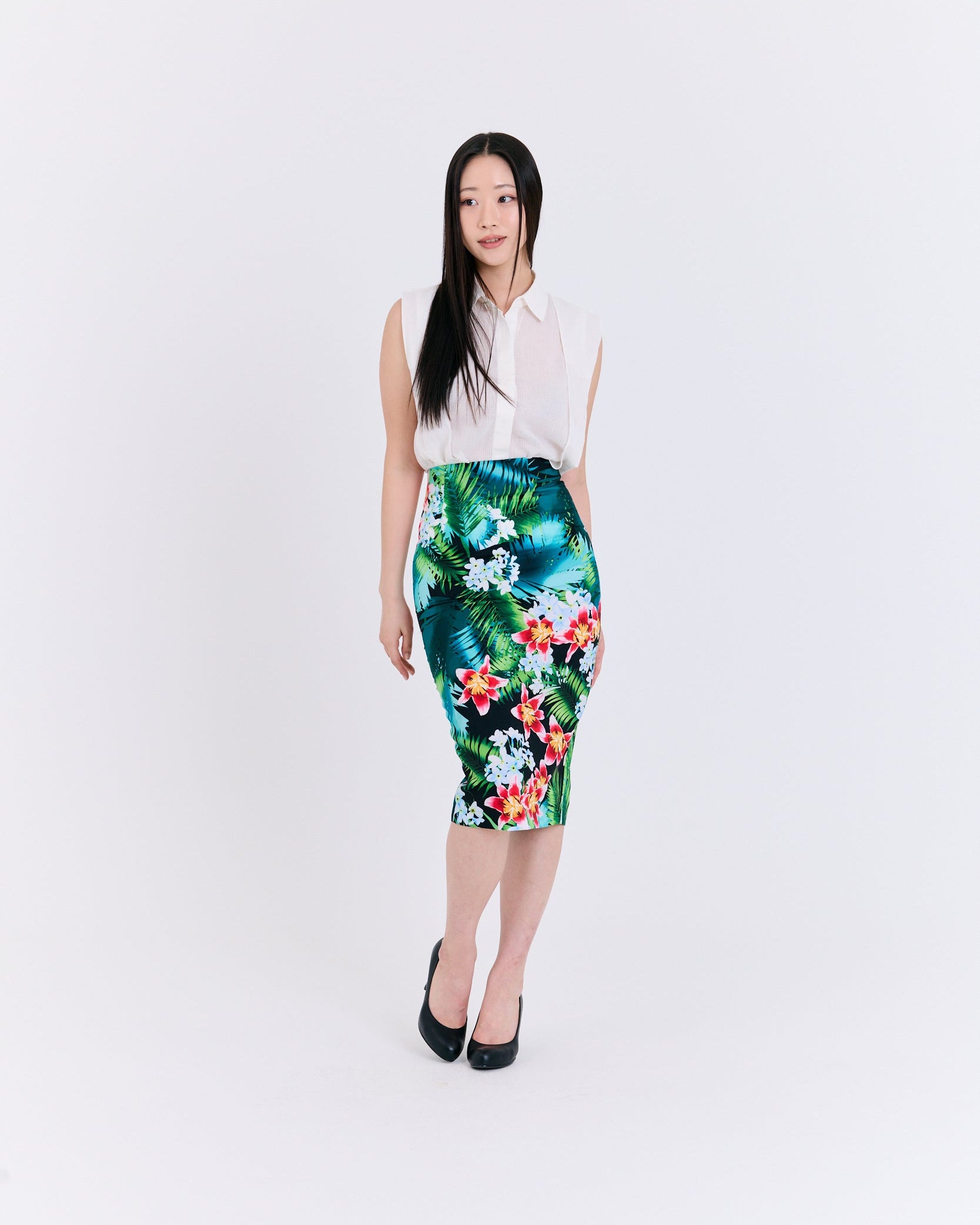Woman wearing a white blouse and floral skirt on a white background