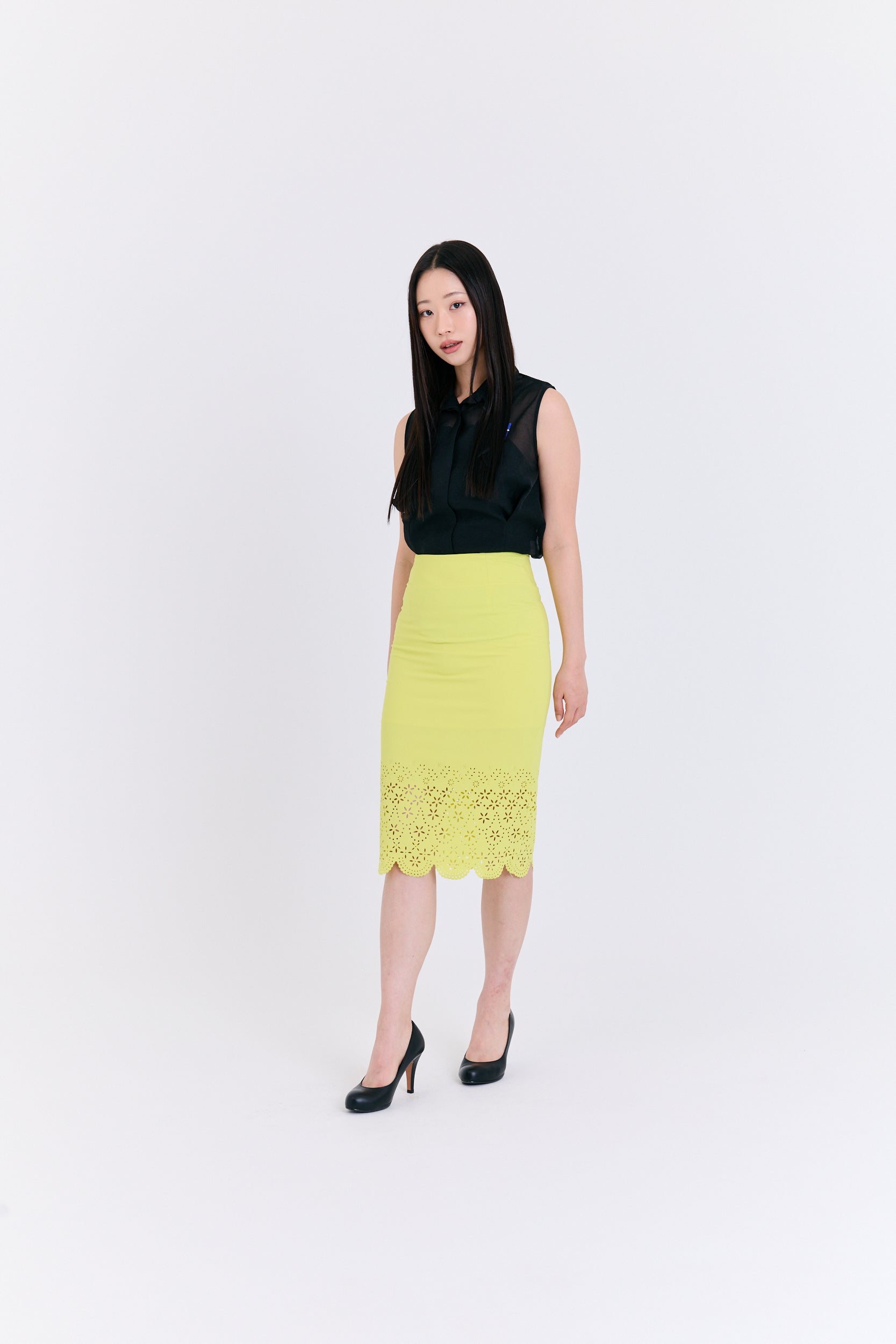 Woman wearing a black top and yellow skirt on a white background