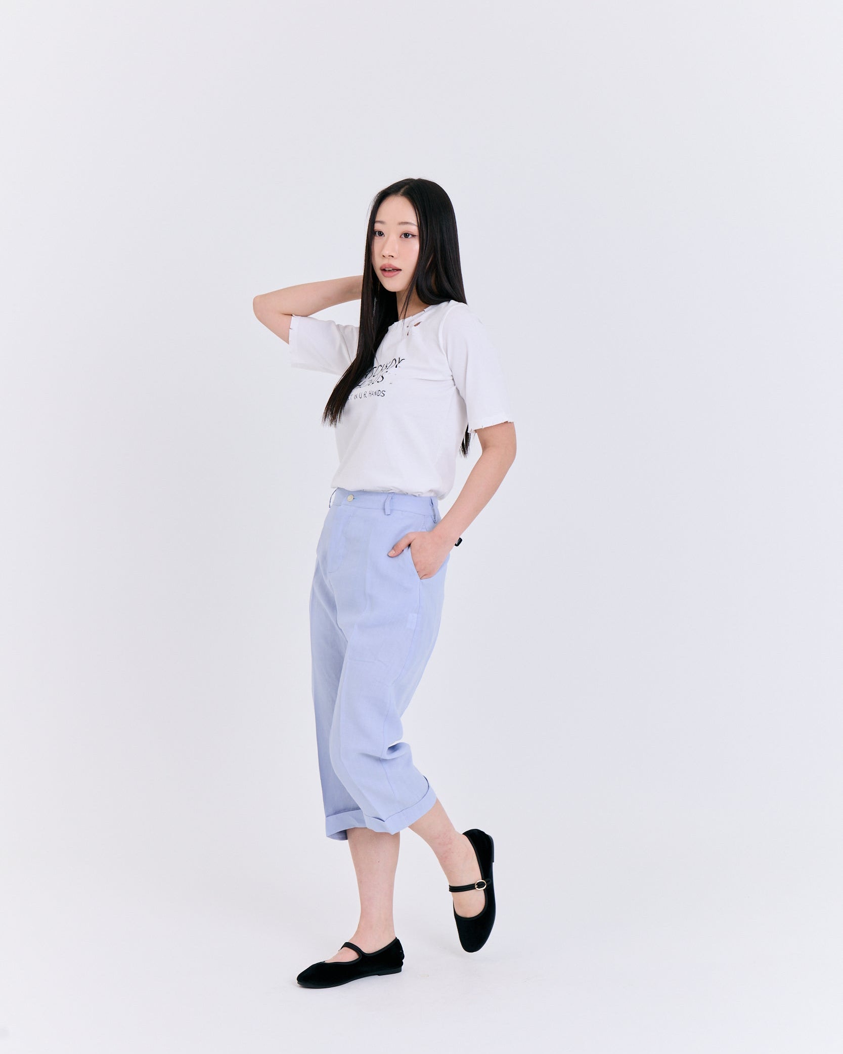 Woman wearing a white t-shirt and light blue pants on a white background