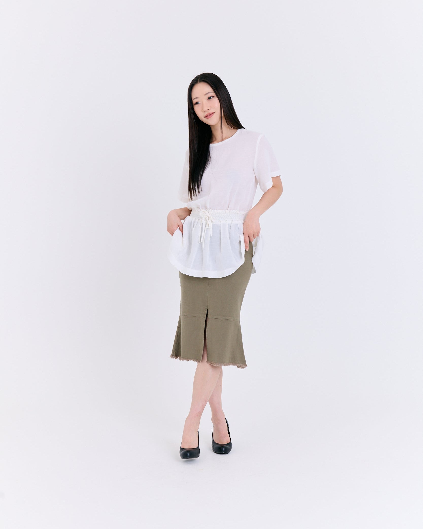 Woman wearing a white top and green skirt on a white background