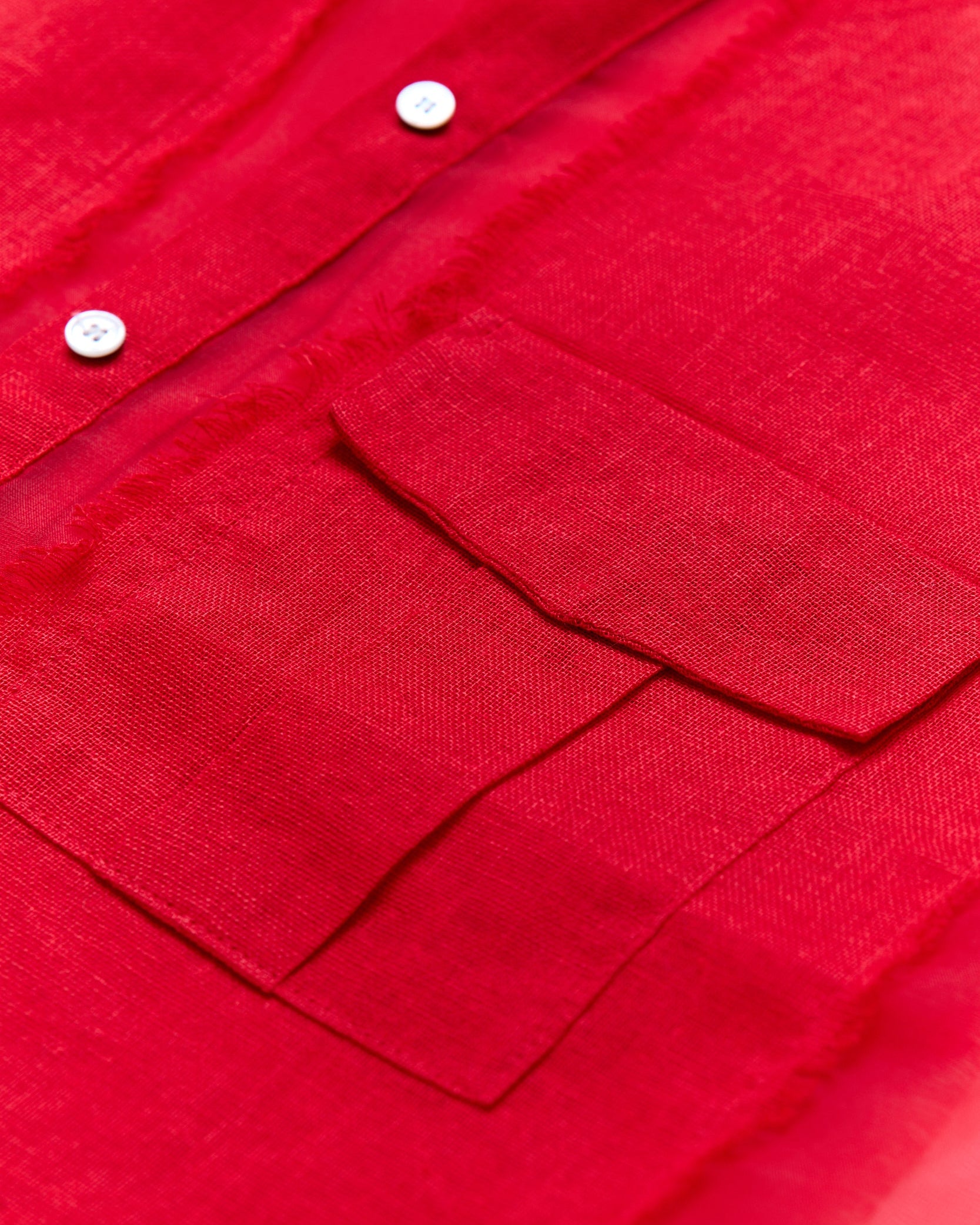 Close-up of a red shirt with buttons and a pocket